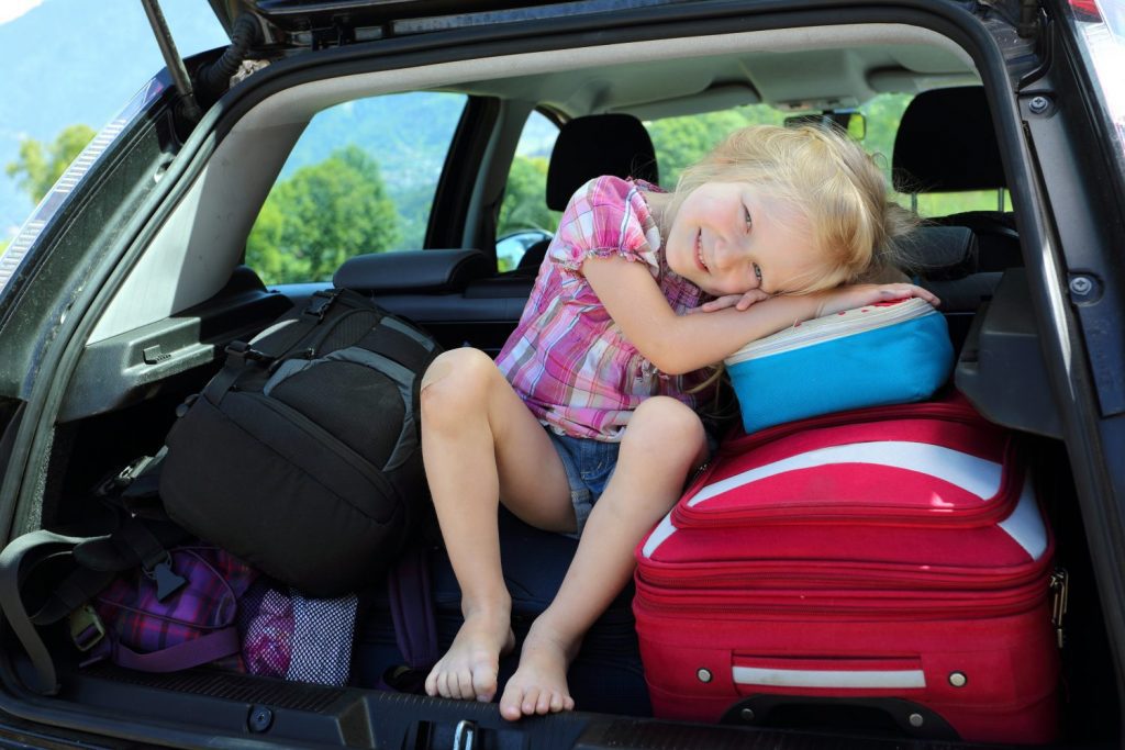 young girl portrait at the car trunk