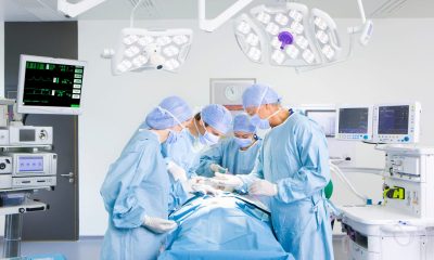 A team of surgeons wearing surgical suits while performing an operation in a fully quipped operating room