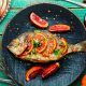 Grilled spicy dorado fish with grapefruit.Roasted fish on old wooden table.Healthy food