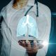 Close up of female doctor hand holding abstract lung hologram on blurry background. Medicine and healthcare concept