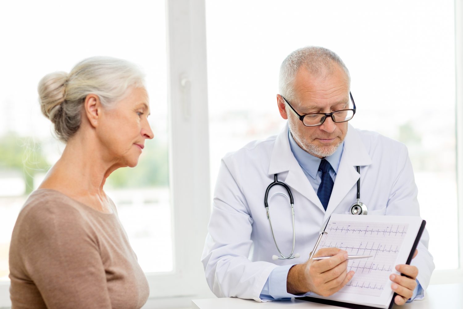 medicine, age, health care and people concept - senior woman and doctor meeting in medical office