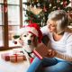 Senior woman with her dog opening Christmas presents.